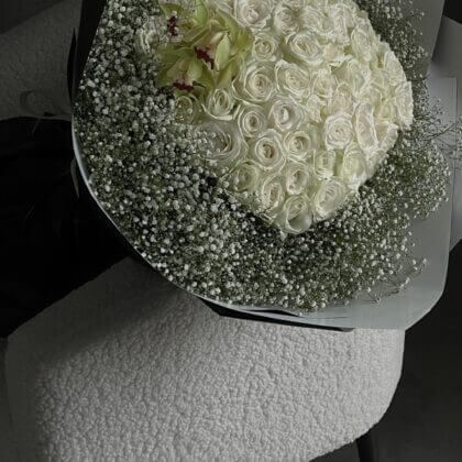 100 white roses surrounded by baby breath