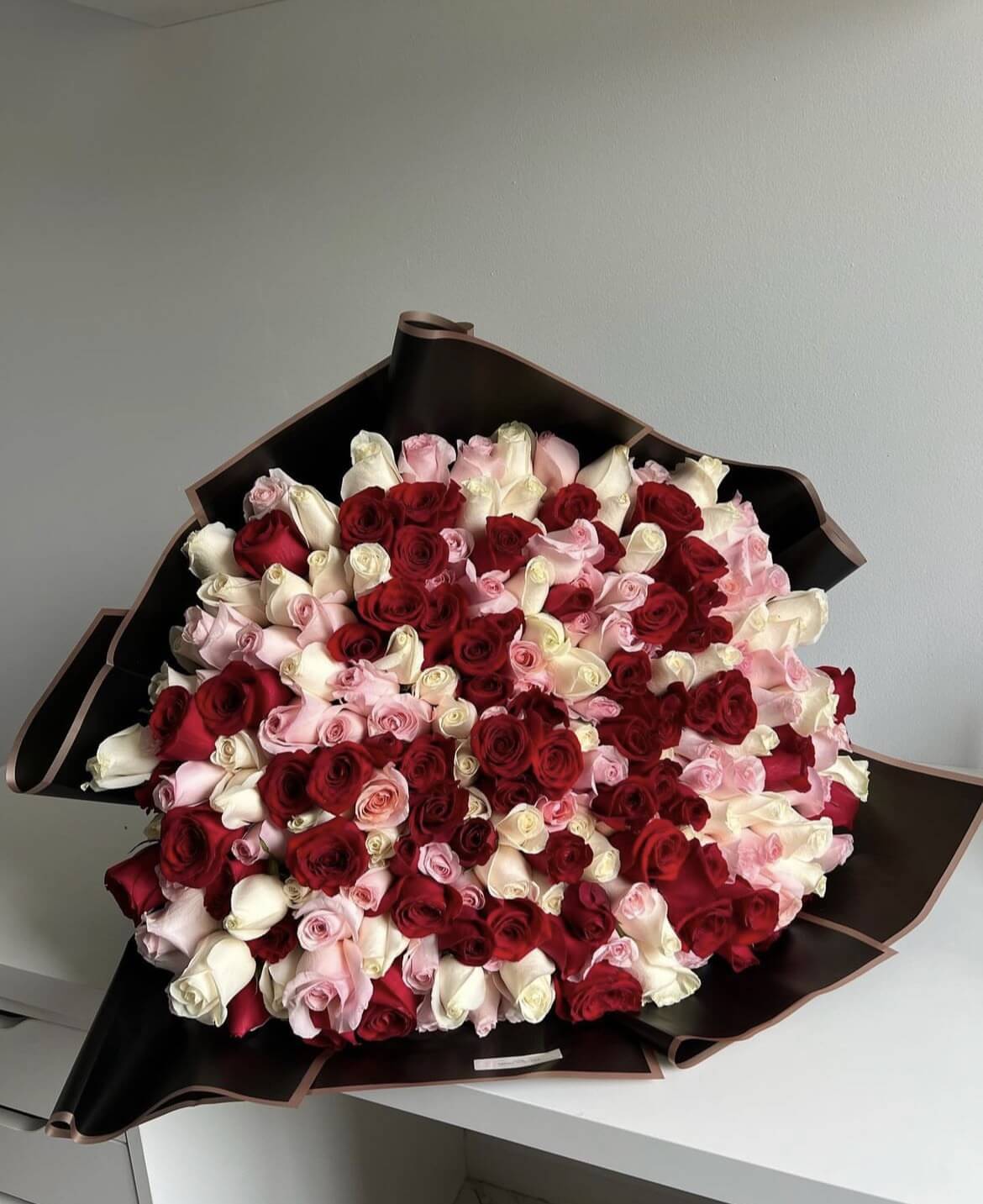 Red, white & light pink roses in black wrapping - 150 stems