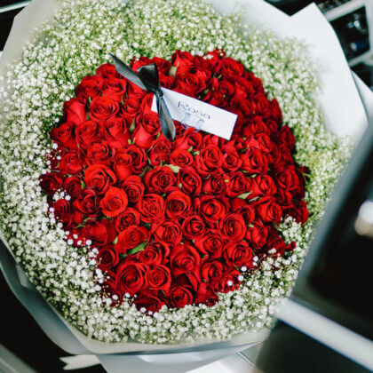 100 red roses surrounded by baby breath
