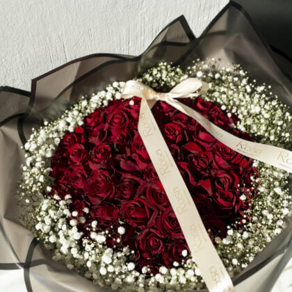 50 red roses surrounded by baby breath -black wrapping