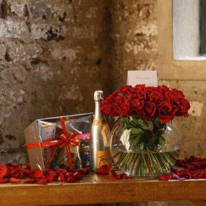 perfect trio- 60 roses in fish bowl vase, veuve rich champagne, lindt gift box