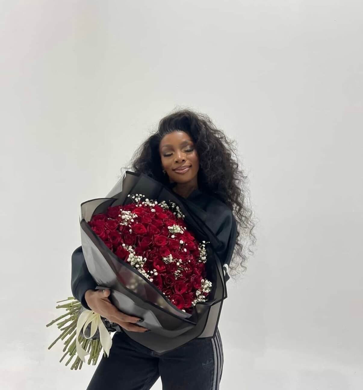 Red roses with baby breath inbetween- black wrapping